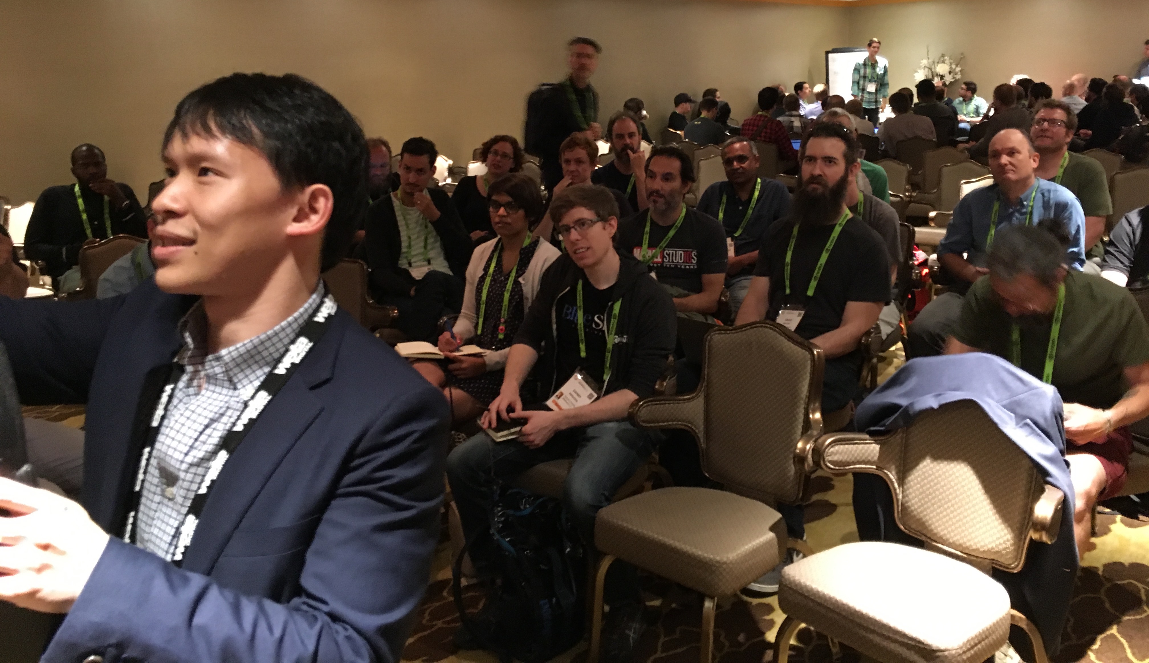A full room of pipeline professionals listening to a talk, with an attendee standing to ask a question.