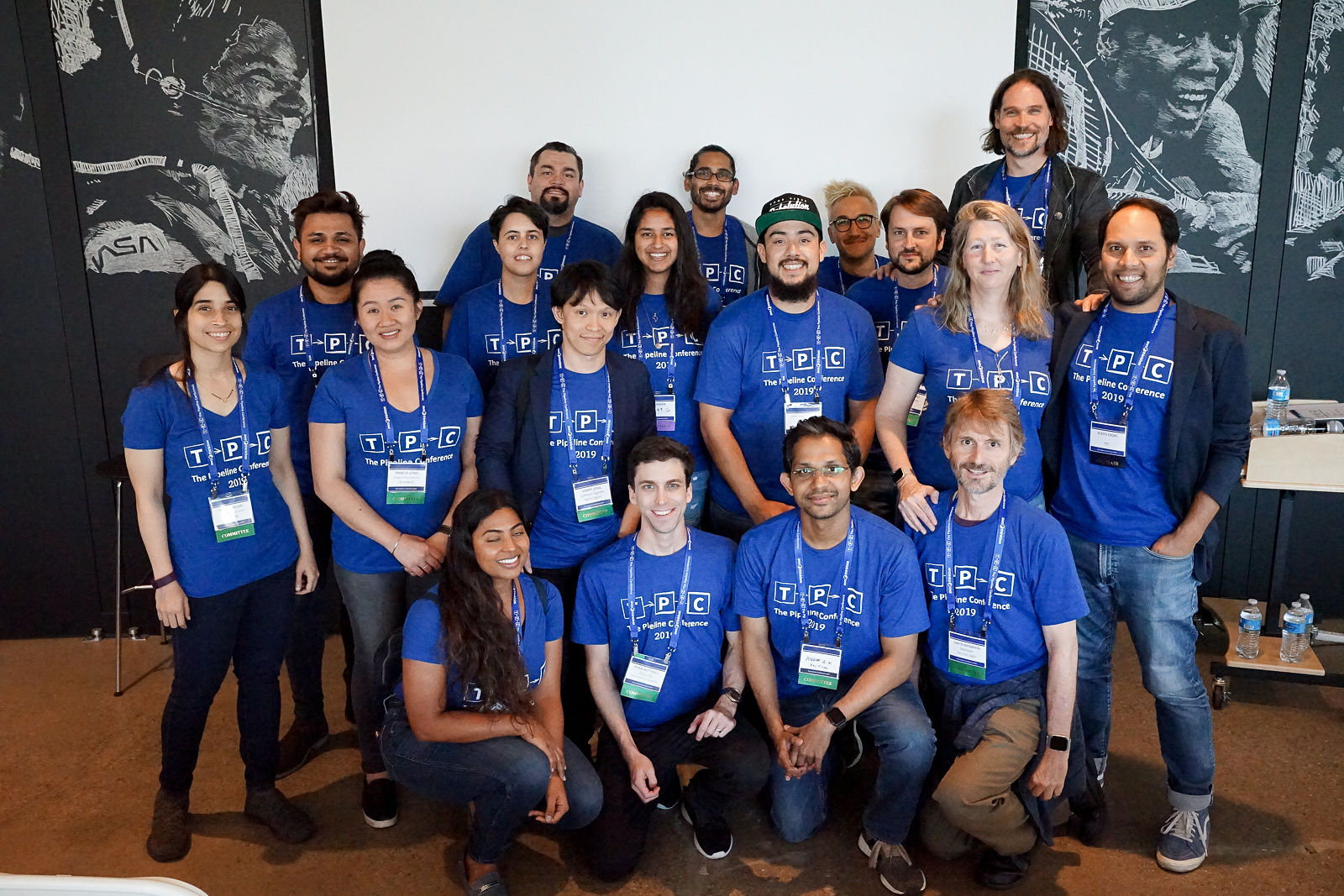 A group of The Pipeline Conference attendees and volunteers in TPC t-shirts, posing together at the 2019 event.